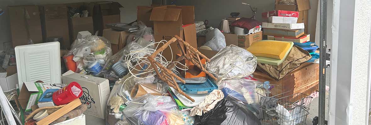 Picture of a garage at a home with lots of junk that needs to be removed
