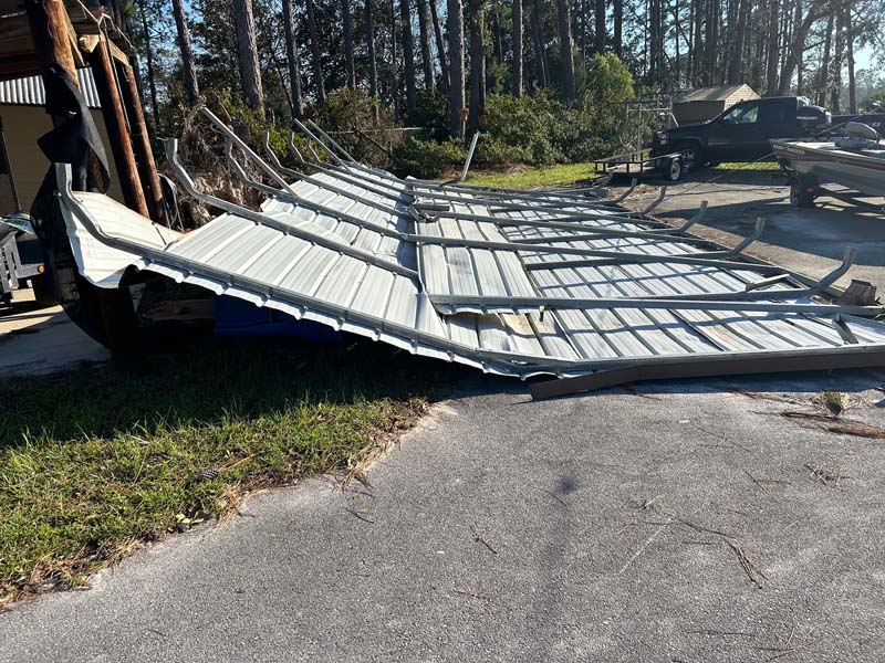 Picture of a roof blown off by storm needing to be hauled away